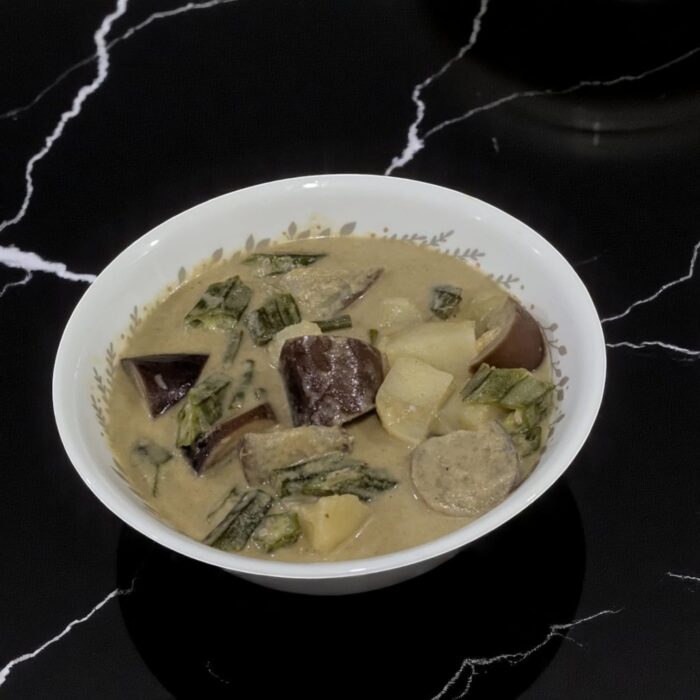 A bowl of rice with a piece of chicken on a table, labeled as SpicyMama Chicken Rice.