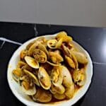 A plate of Kam Hiong stir-fried clams garnished with SpicyMama KAM HIONG SAUCE,