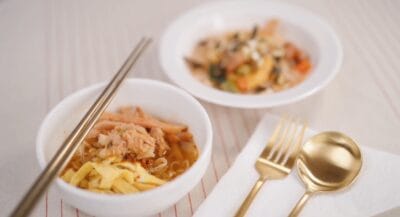 A bowl of Yuzu Cold Noodle accompanied by chopsticks and a spoon, arranged neatly on a table.