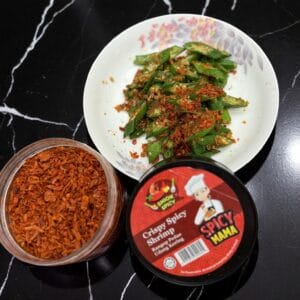 An open jar of spicymama cruspy shrimp with a dish of SpicyMama Crispy Shrimp and okra in the background.