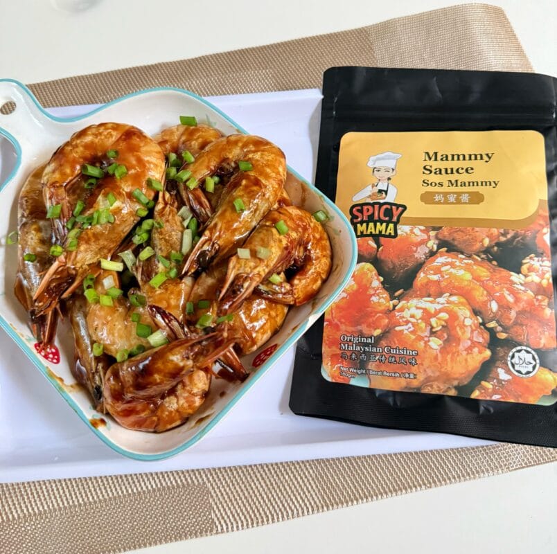 On a tray, a bowl of shrimp is accompanied by a bag of seasoning, ideal for enhancing flavor.