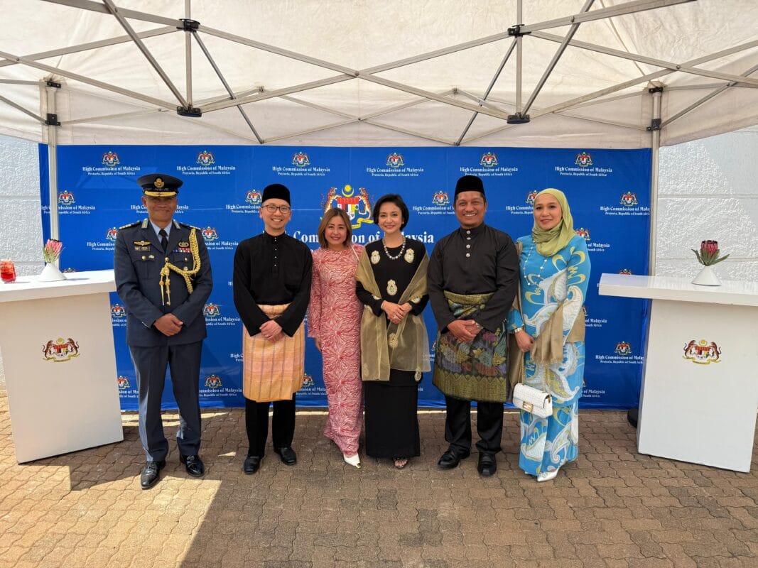 A group of people of various ages and backgrounds standing under a tent, participating in a social event outdoors.