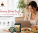 A woman uses her laptop to follow a recipe while cooking in a modern kitchen filled with fresh ingredients from spicymama